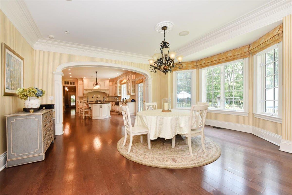 1616 Stewart Lane Syosset, NY 11791 - Photo 18 of 38 Dining area with arched walkways, a chandelier, dark wood finished floors, and ornamental molding