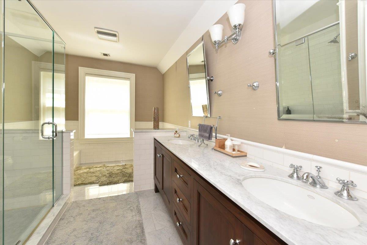 1616 Stewart Lane Syosset, NY 11791 - Photo 26 of 38 Full bathroom featuring a shower stall, double vanity, tile walls, a wainscoted wall, and tile patterned floors