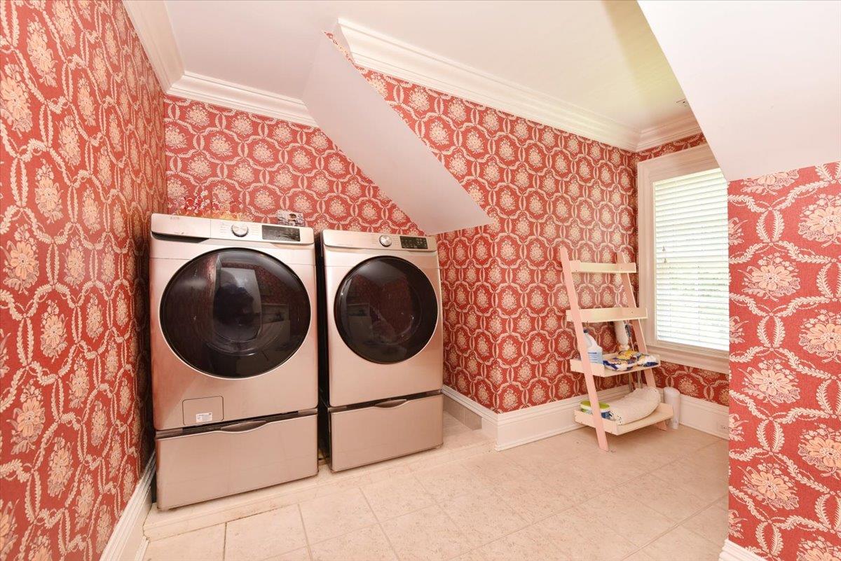 1616 Stewart Lane Syosset, NY 11791 - Photo 29 of 38 Laundry room featuring washer and clothes dryer, wallpapered walls, and crown molding