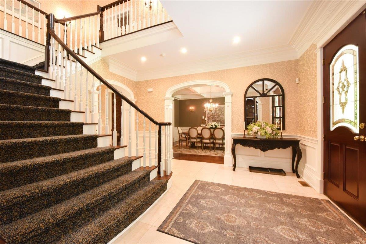 1616 Stewart Lane Syosset, NY 11791 - Photo 8 of 38 Foyer entrance featuring decorative columns, ornamental molding, arched walkways, stairs, and a decorative wall