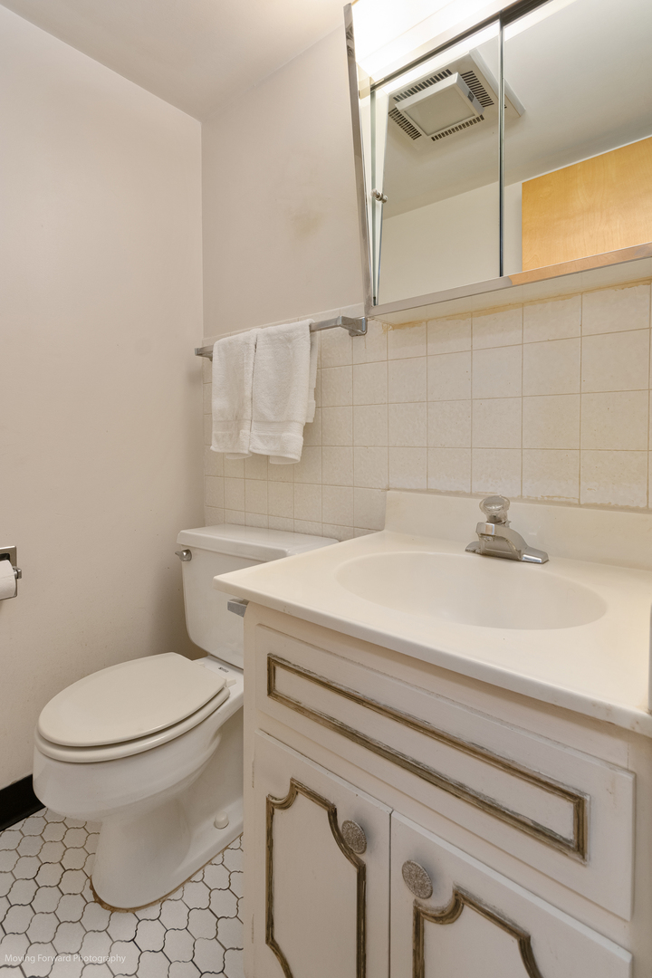 2900 Maple Avenue, Unit 13C Downers Grove, IL 60515 - Photo 20 of 36 a bathroom with a sink a toilet and a mirror