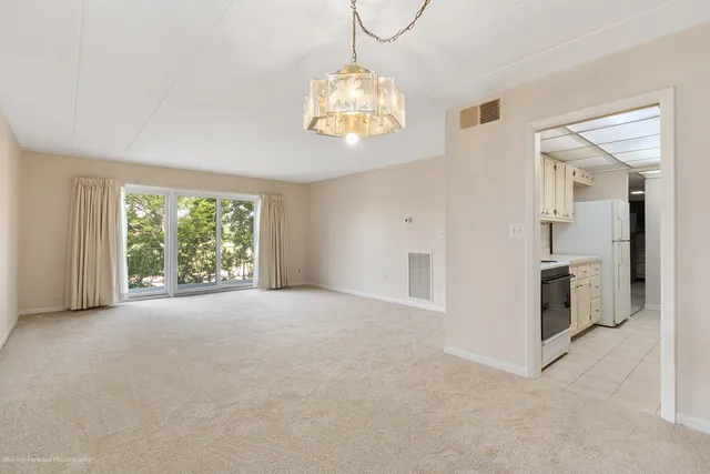 an empty room with windows and chandelier