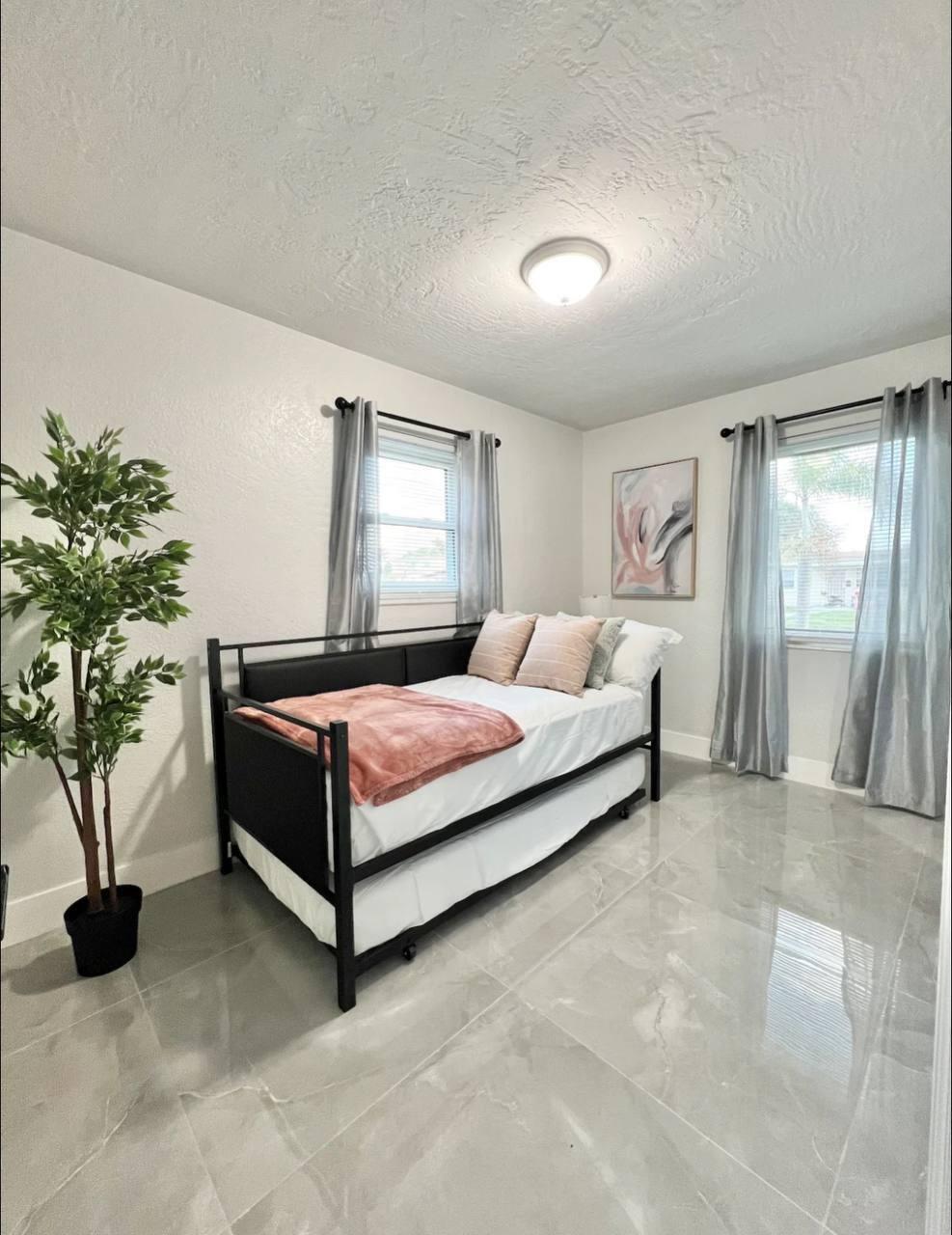 1353 9th Street West Palm Beach, FL 33401 - Photo 7 of 21 a spacious bedroom with a bed lamp and a potted plant