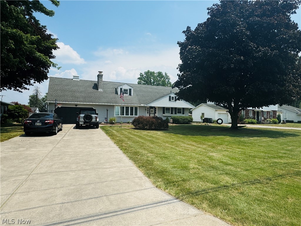 Cape cod home with a garage and a front lawn