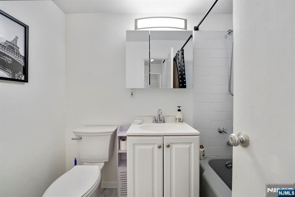 90 Prospect Avenue, Unit 8C Hackensack, NJ 07601 - Photo 15 of 29 a bathroom with a sink toilet and mirror