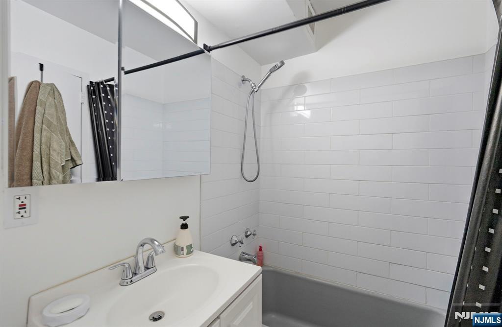 90 Prospect Avenue, Unit 8C Hackensack, NJ 07601 - Photo 16 of 29 a bathroom with a sink and a mirror