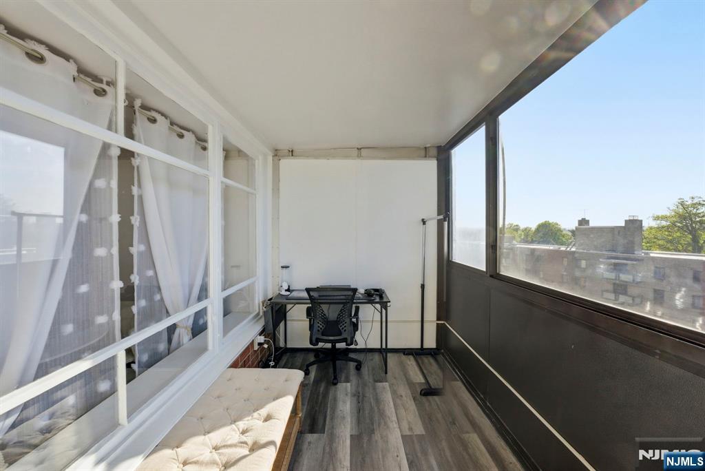 90 Prospect Avenue, Unit 8C Hackensack, NJ 07601 - Photo 7 of 29 a view of a balcony with chair and wooden floor