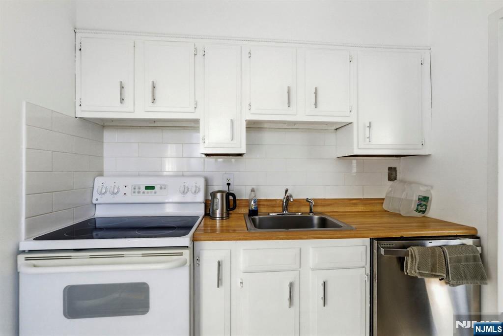 90 Prospect Avenue, Unit 8C Hackensack, NJ 07601 - Photo 10 of 29 a kitchen with stainless steel appliances a stove a refrigerator a sink and cabinets