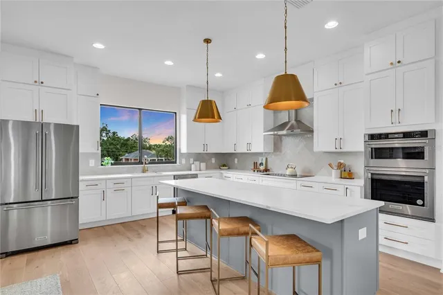a kitchen with white cabinets and stainless steel appliances