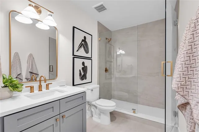 a bathroom with a toilet a sink and glass door