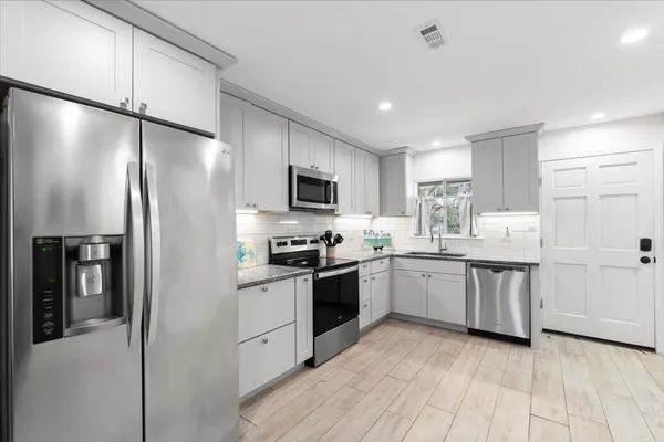 a kitchen with a refrigerator a sink and wooden cabinets