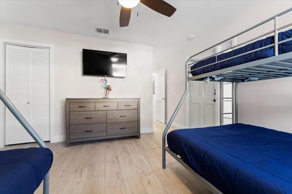 a bedroom with a bed and a flat tv screen on dresser