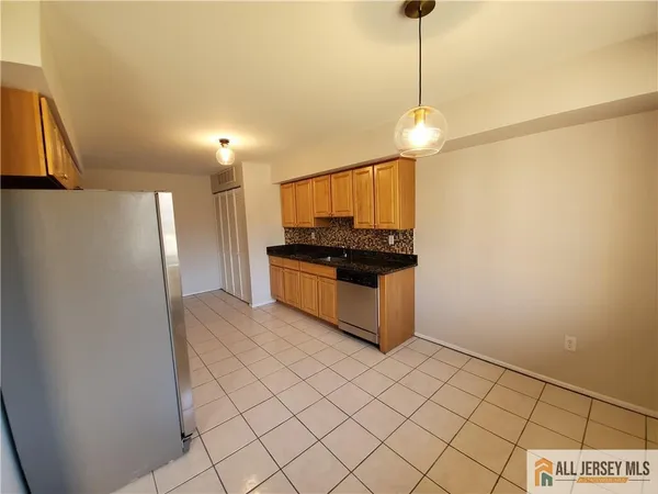 a kitchen with stainless steel appliances granite countertop a refrigerator a sink and a stove