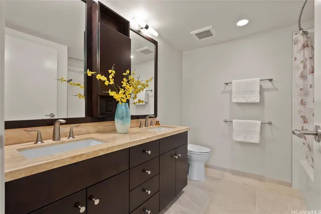 a bathroom with a granite countertop sink toilet and large mirror