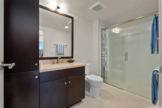 a bathroom with a double vanity sink toilet mirror and shower