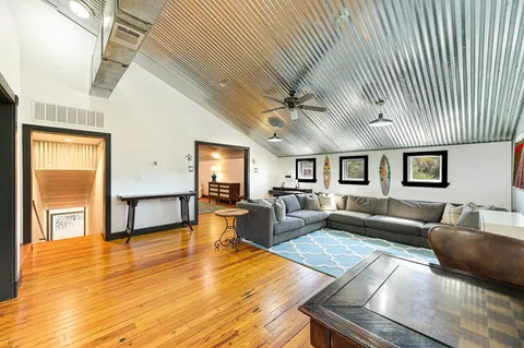 a living room with furniture and a wooden floor