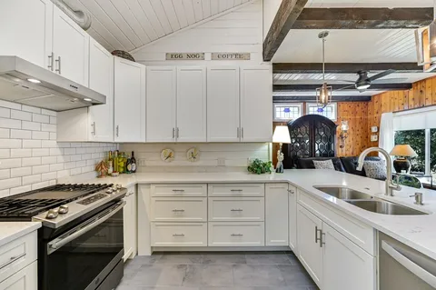 a kitchen with a stove and white cabinets