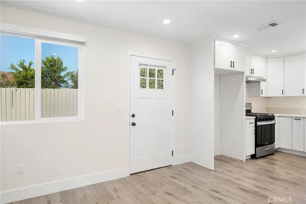 a view of kitchen with wooden floor electronic appliances and window