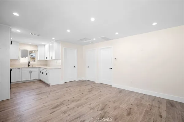 a large kitchen with a lot of cabinets and wooden floor