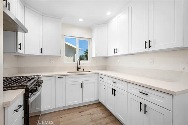 a kitchen with white cabinets and white appliances