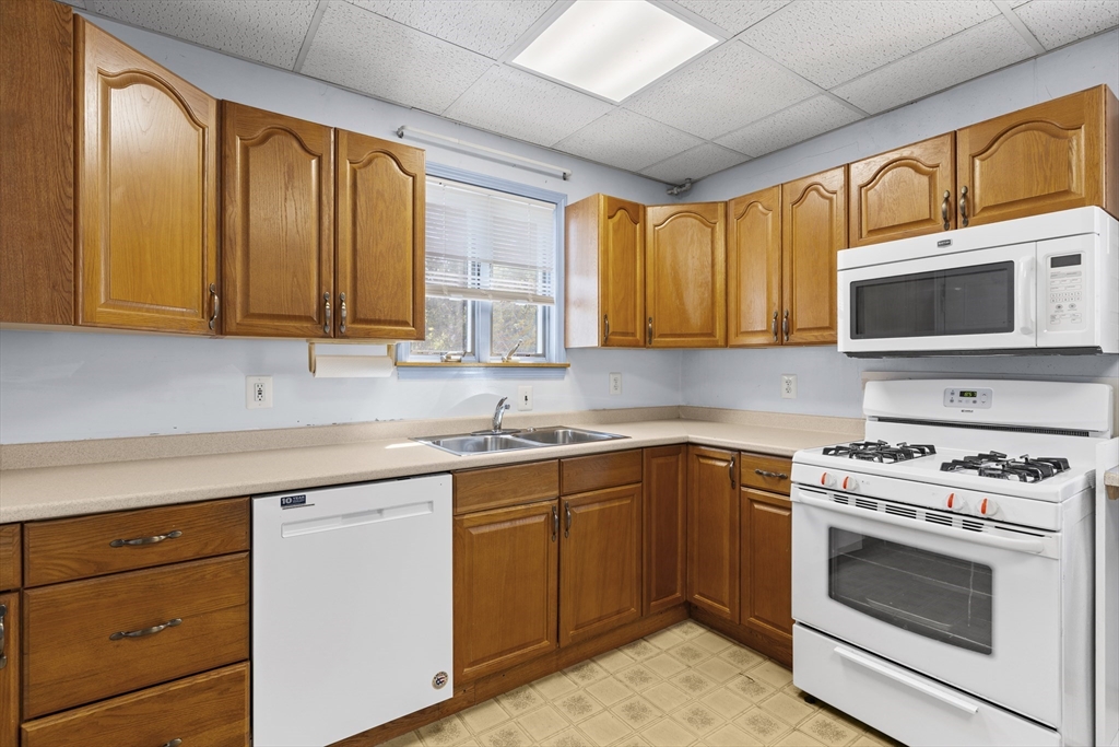 10 Alcott Street Boston, MA 02134 - Photo 10 of 36 a kitchen with stainless steel appliances granite countertop wooden cabinets and a stove top oven