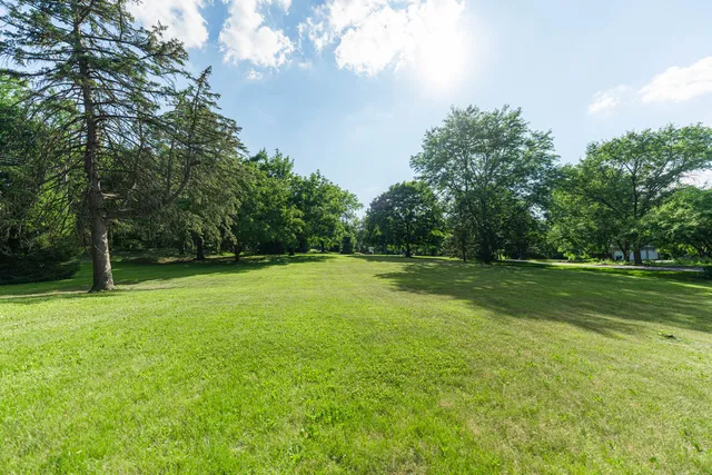 a view of a green field with wooden fence