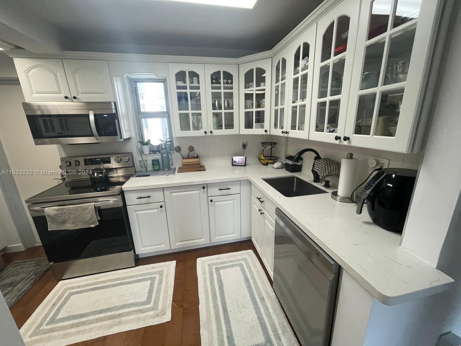1674 Bay Road, Unit 402 Miami Beach, FL 33139 - Photo 7 of 16 a kitchen with stainless steel appliances a stove a sink and a refrigerator