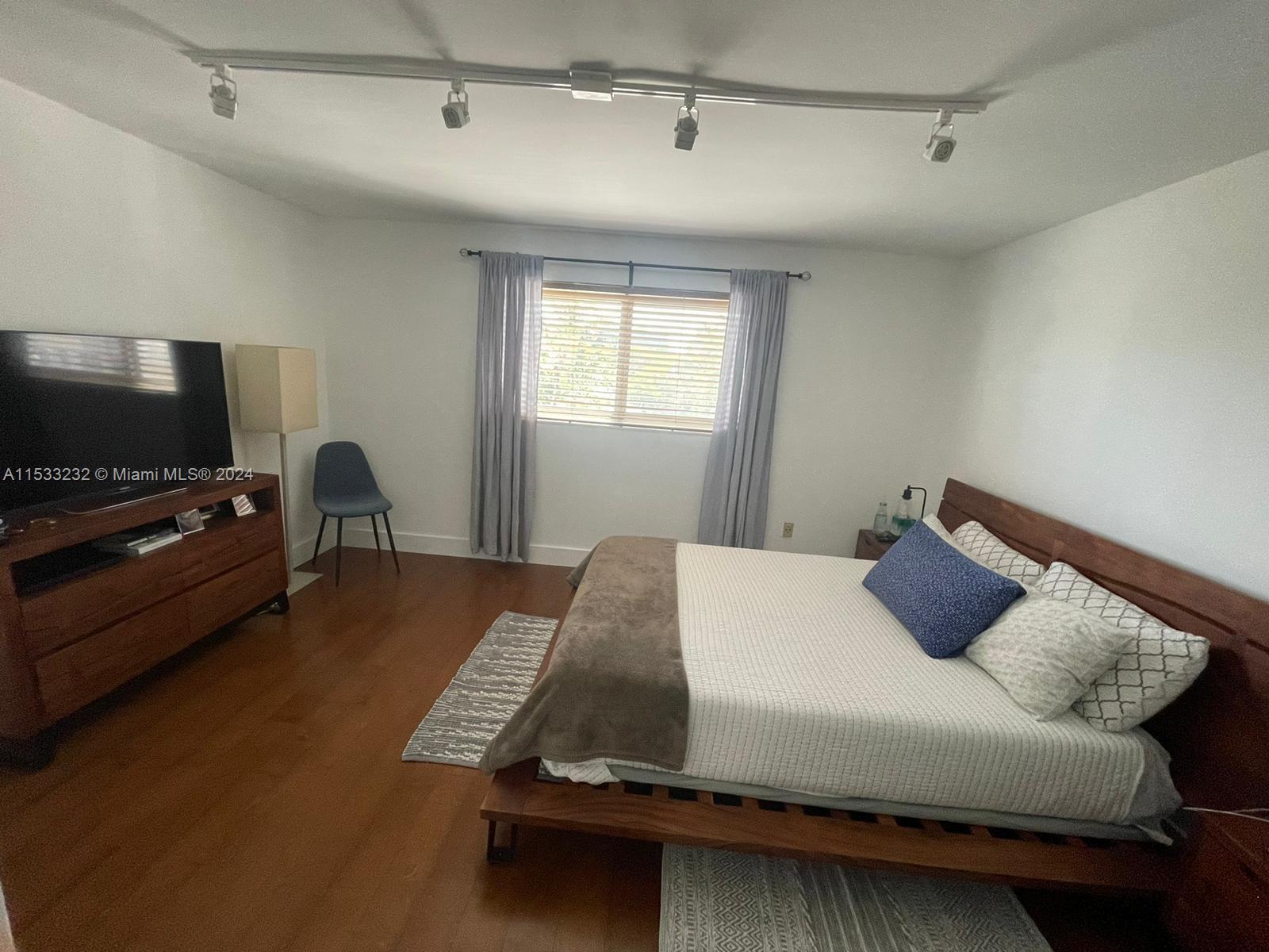 1674 Bay Road, Unit 402 Miami Beach, FL 33139 - Photo 10 of 16 a bedroom with a bed and a flat screen tv