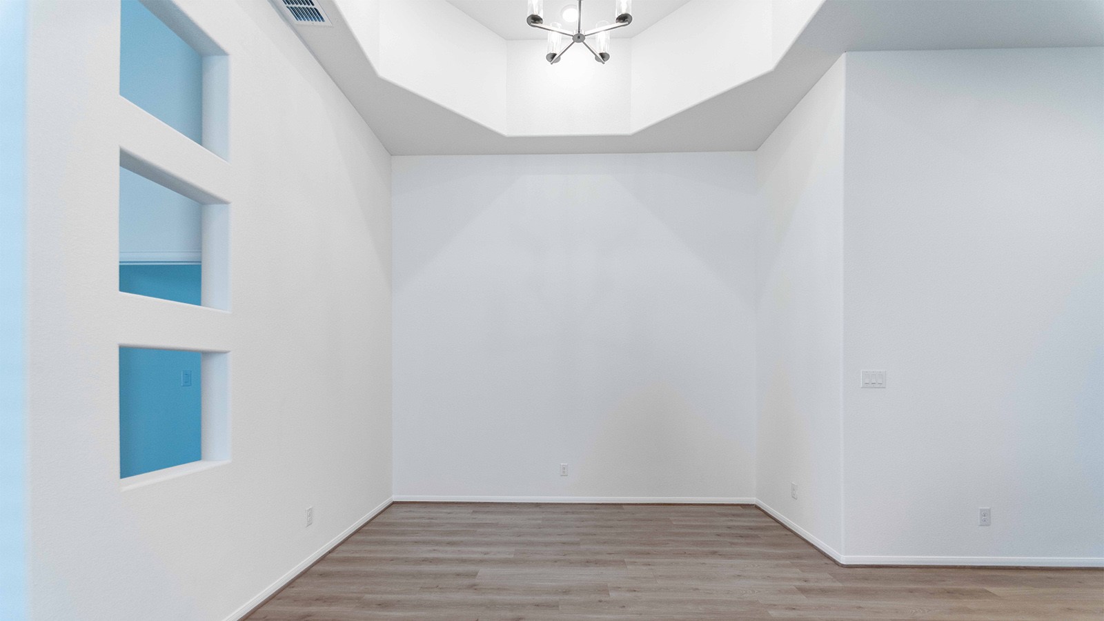 251 Grey Leaf Road Buda, TX 78610 - Photo 8 of 17 Empty room with light wood-style flooring, a chandelier, and a raised ceiling
