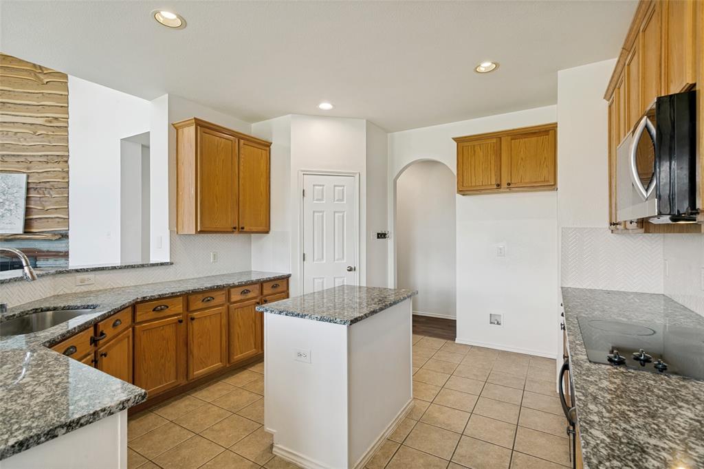 4107 Waverly Road Corinth, TX 76208 - Photo 10 of 30 The kitchen was upgraded in 2020 with granite counter tops and white tile backsplash and features a deep, single bowl stainless steel sink with high-neck faucet and a walk-in pantry.