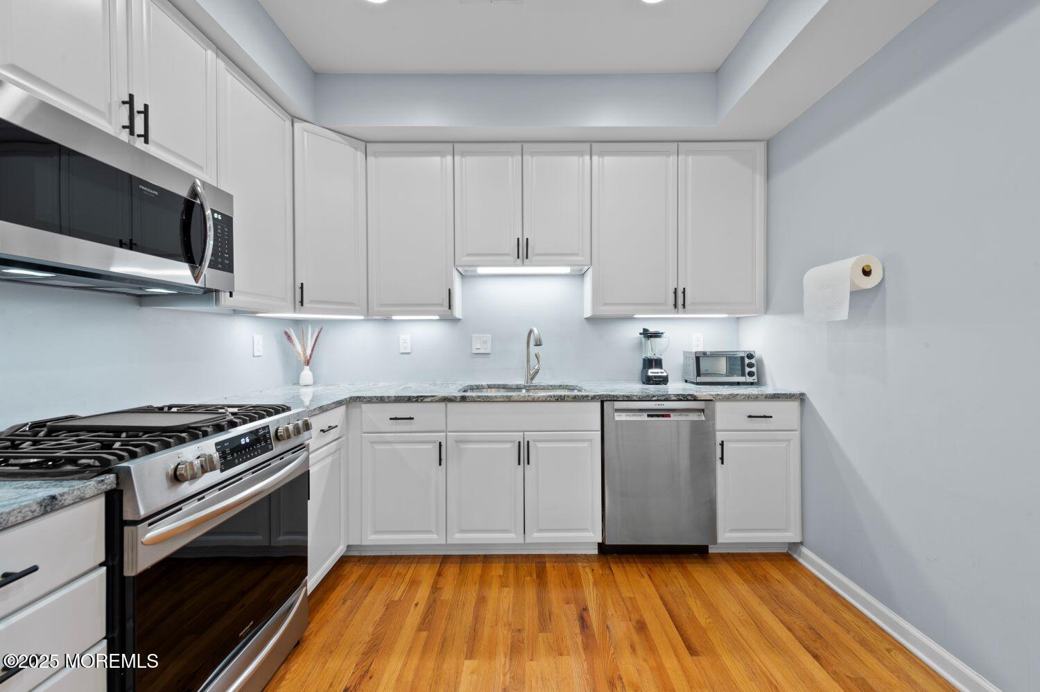 162 Main Street Manasquan, NJ 08736 - Photo 11 of 48 a kitchen with granite countertop cabinets stainless steel appliances and wooden floor