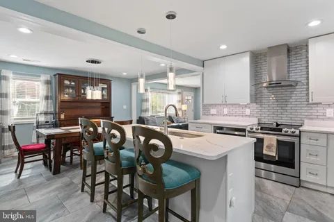 a kitchen with sink a stove and chairs