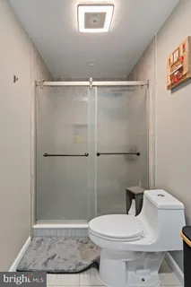 a white toilet sitting next to a shower