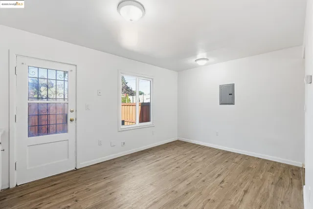 an empty room with wooden floor and windows