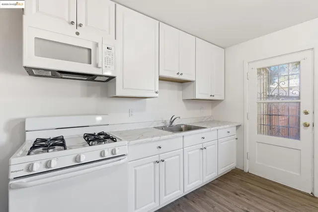 a kitchen with white cabinets and white appliances