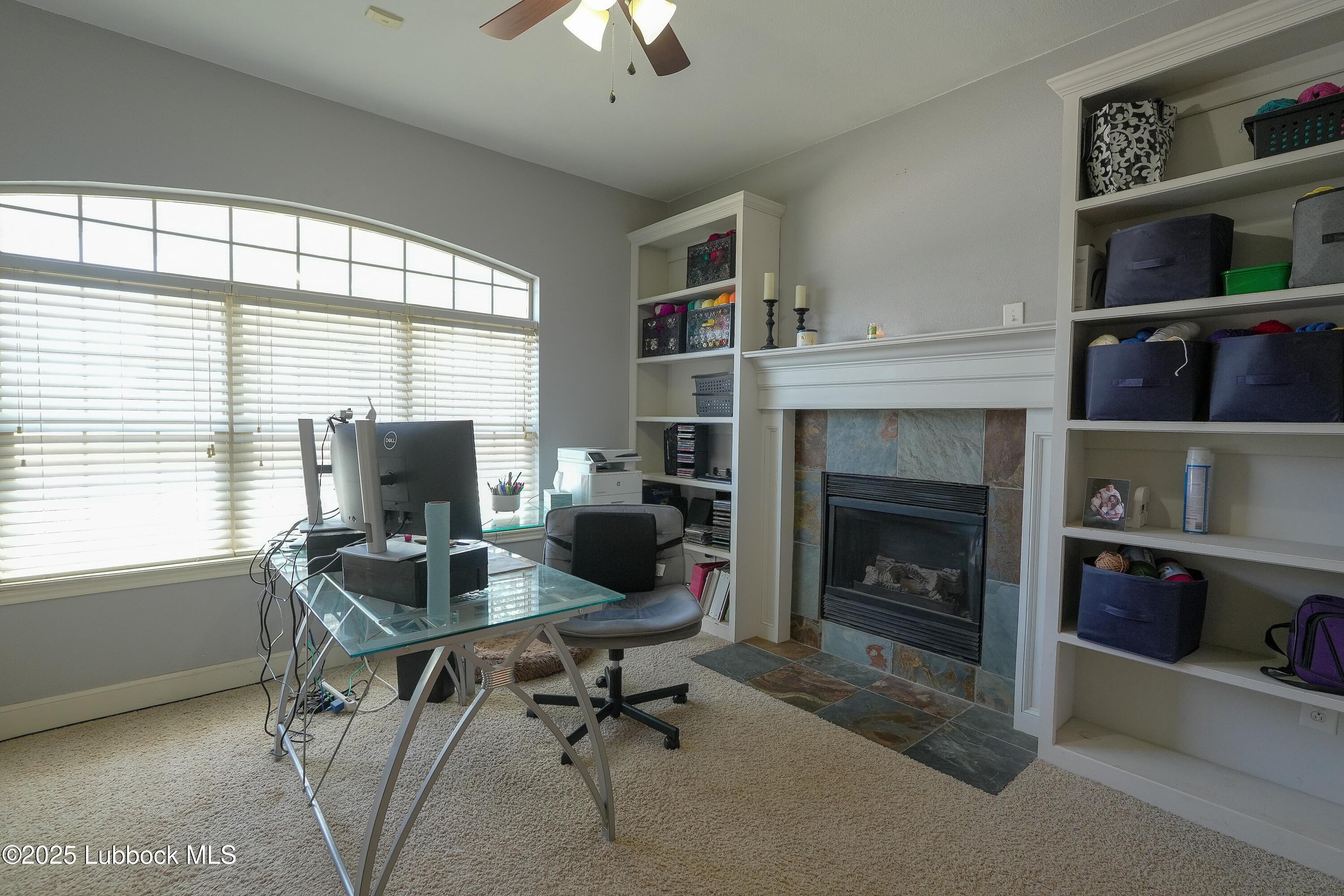 5904 110th Street Lubbock, TX 79424 - Photo 12 of 32 a livingroom with workspace fireplace and window