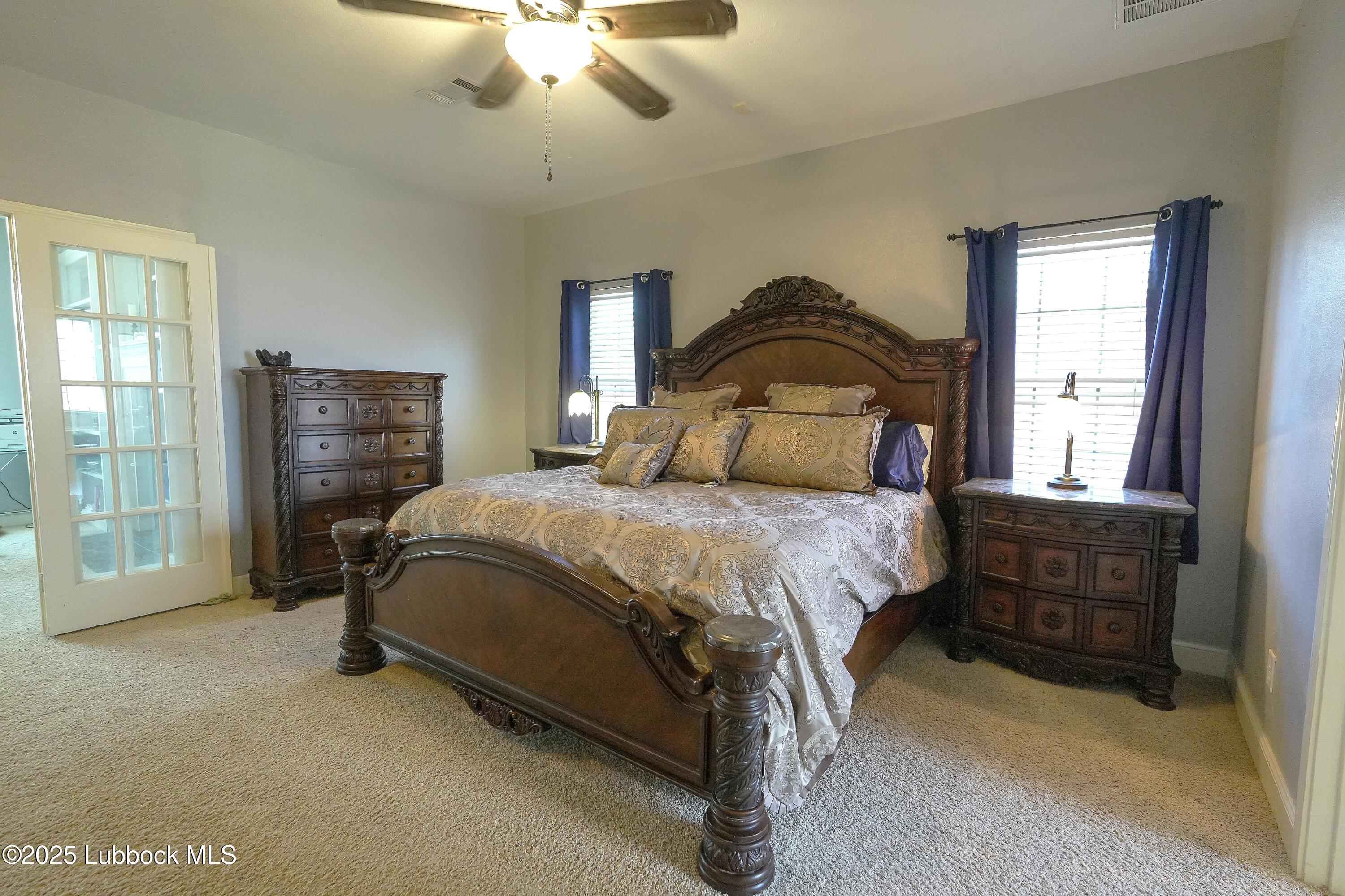 5904 110th Street Lubbock, TX 79424 - Photo 13 of 32 a bedroom with a bed and a chandelier