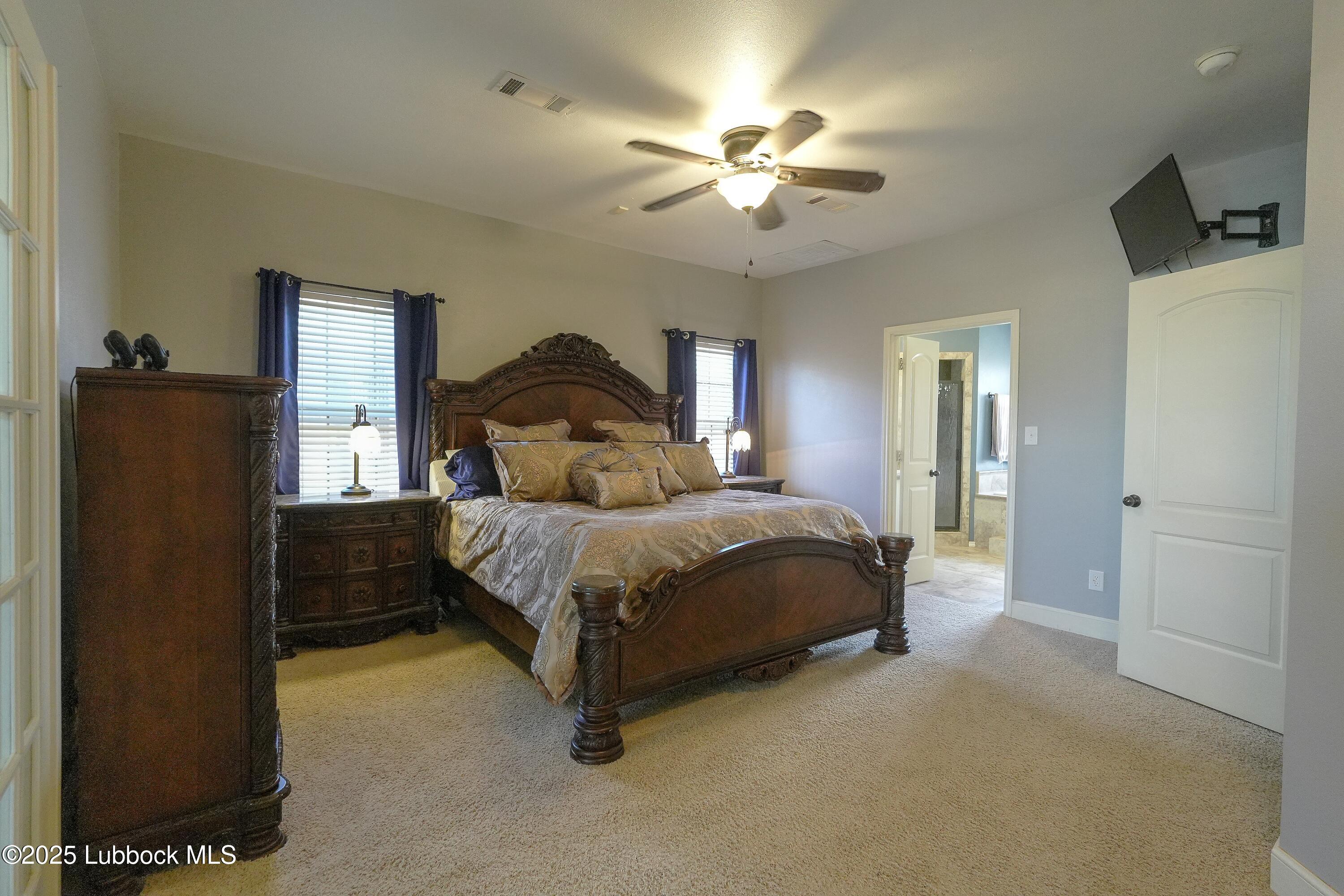 5904 110th Street Lubbock, TX 79424 - Photo 14 of 32 a bedroom with a bed and a chandelier