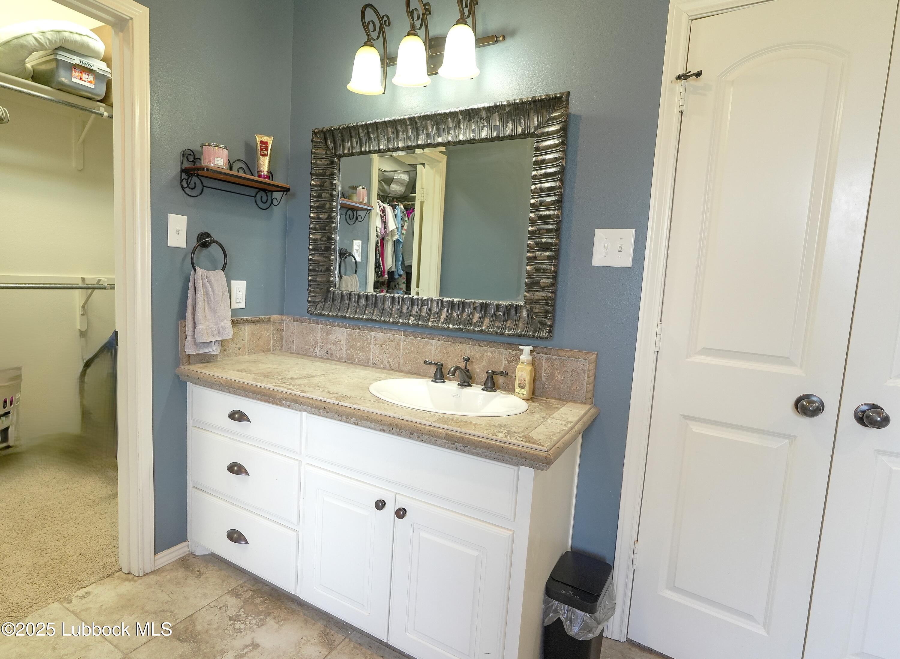 5904 110th Street Lubbock, TX 79424 - Photo 15 of 32 a bathroom with a sink and a mirror