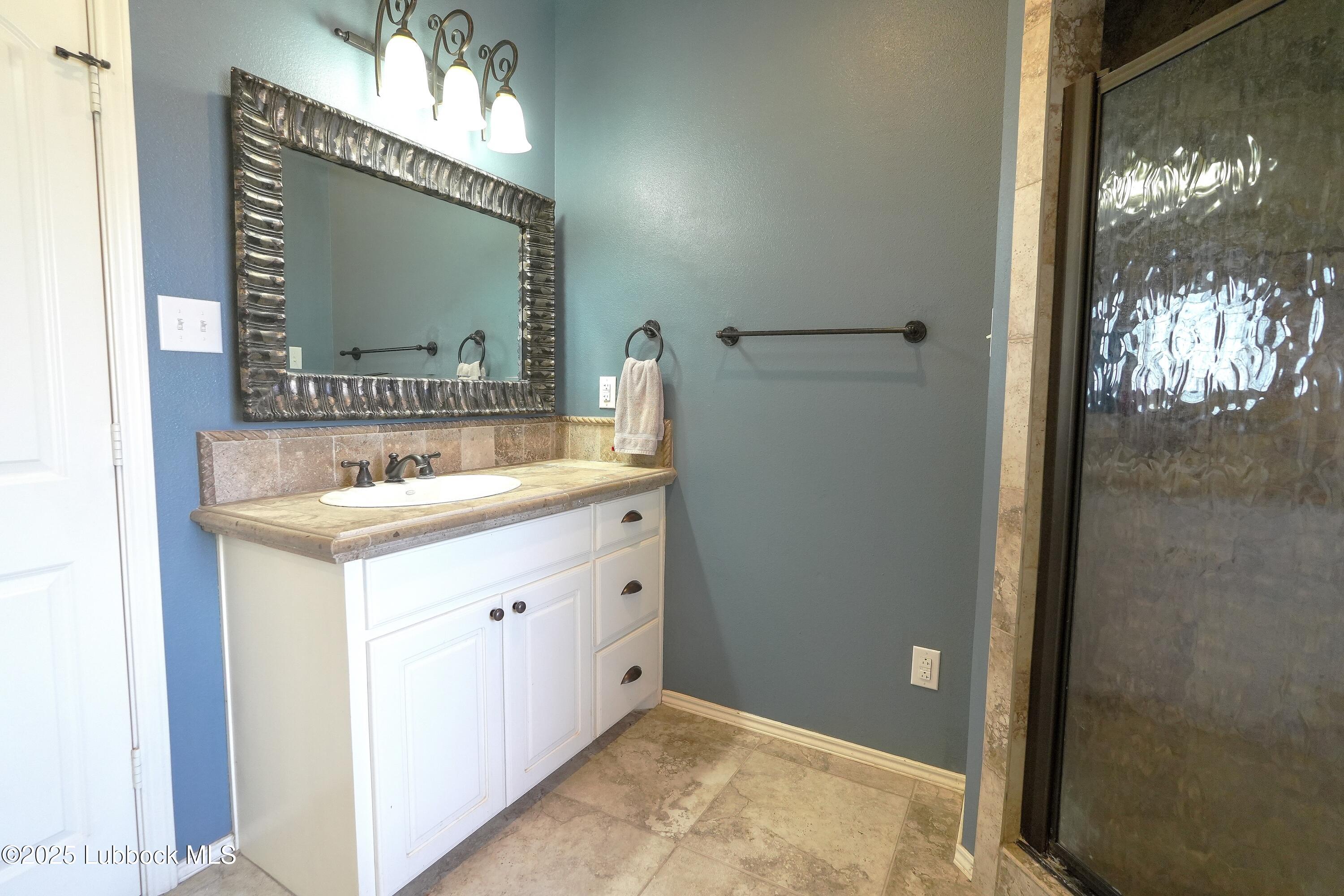 5904 110th Street Lubbock, TX 79424 - Photo 17 of 32 a bathroom with a sink mirror and a shower