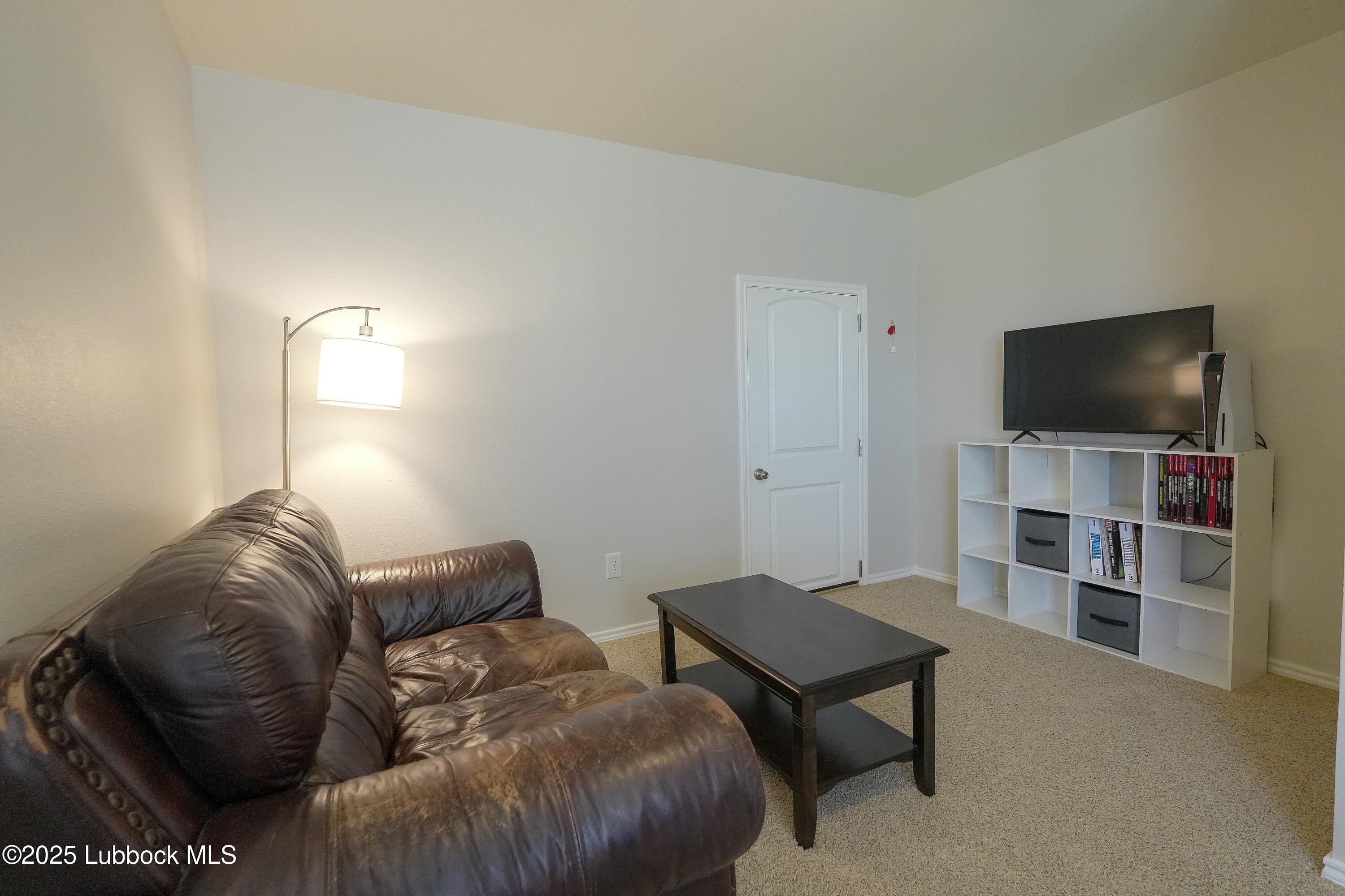 5904 110th Street Lubbock, TX 79424 - Photo 20 of 32 a living room with furniture and a flat screen tv