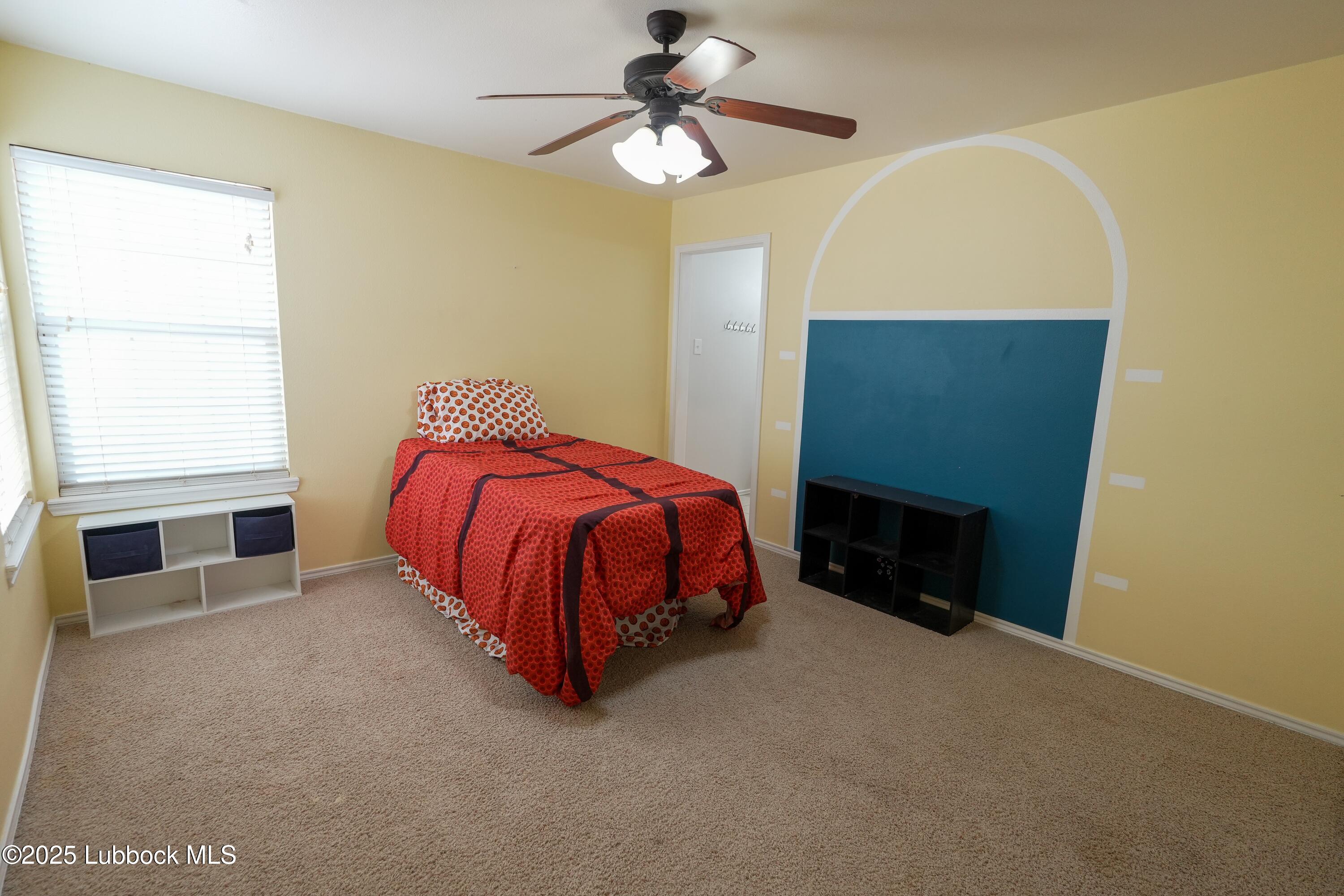 5904 110th Street Lubbock, TX 79424 - Photo 21 of 32 a bedroom with a bed and a ceiling fan