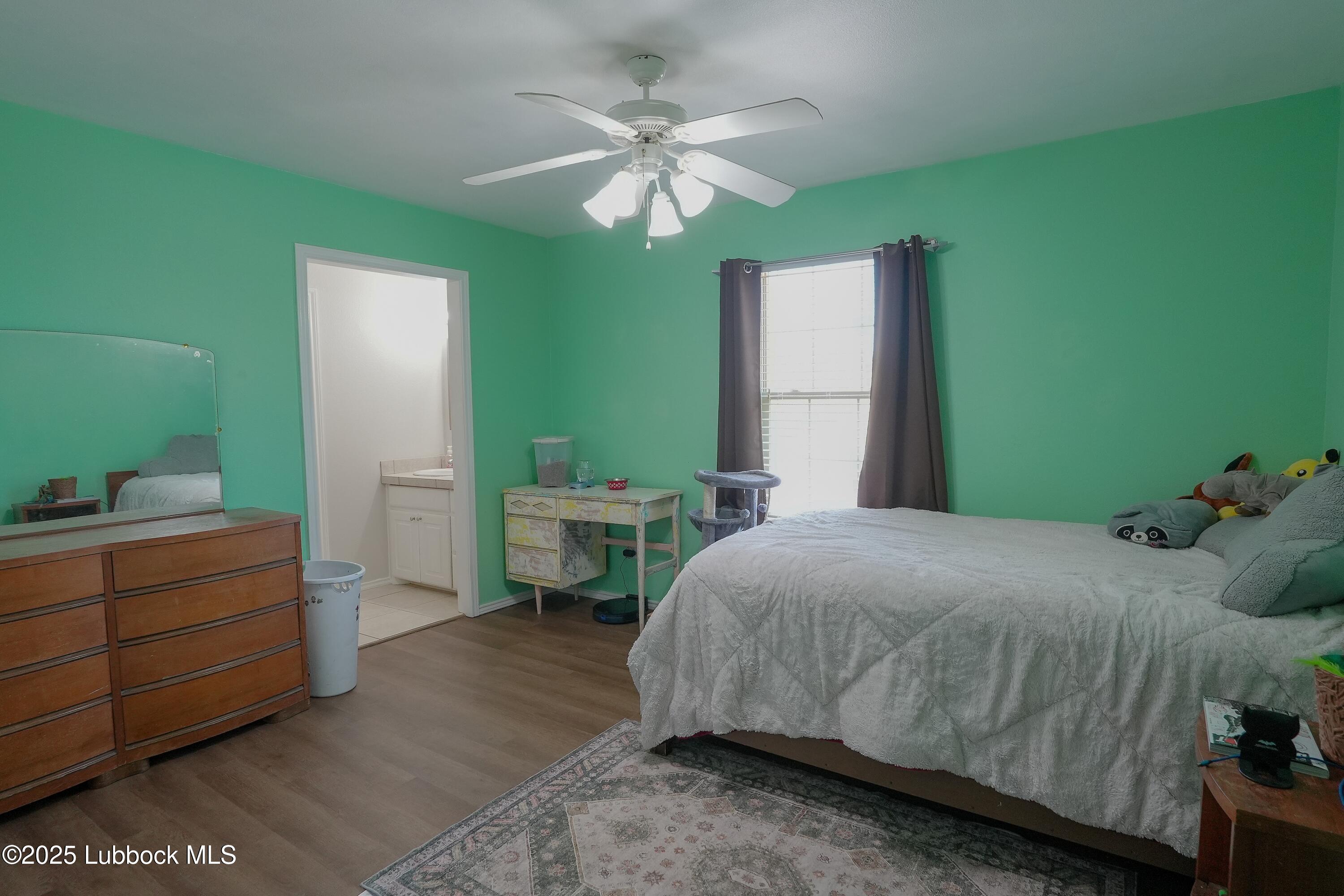 5904 110th Street Lubbock, TX 79424 - Photo 22 of 32 a bedroom with a bed and a chandelier