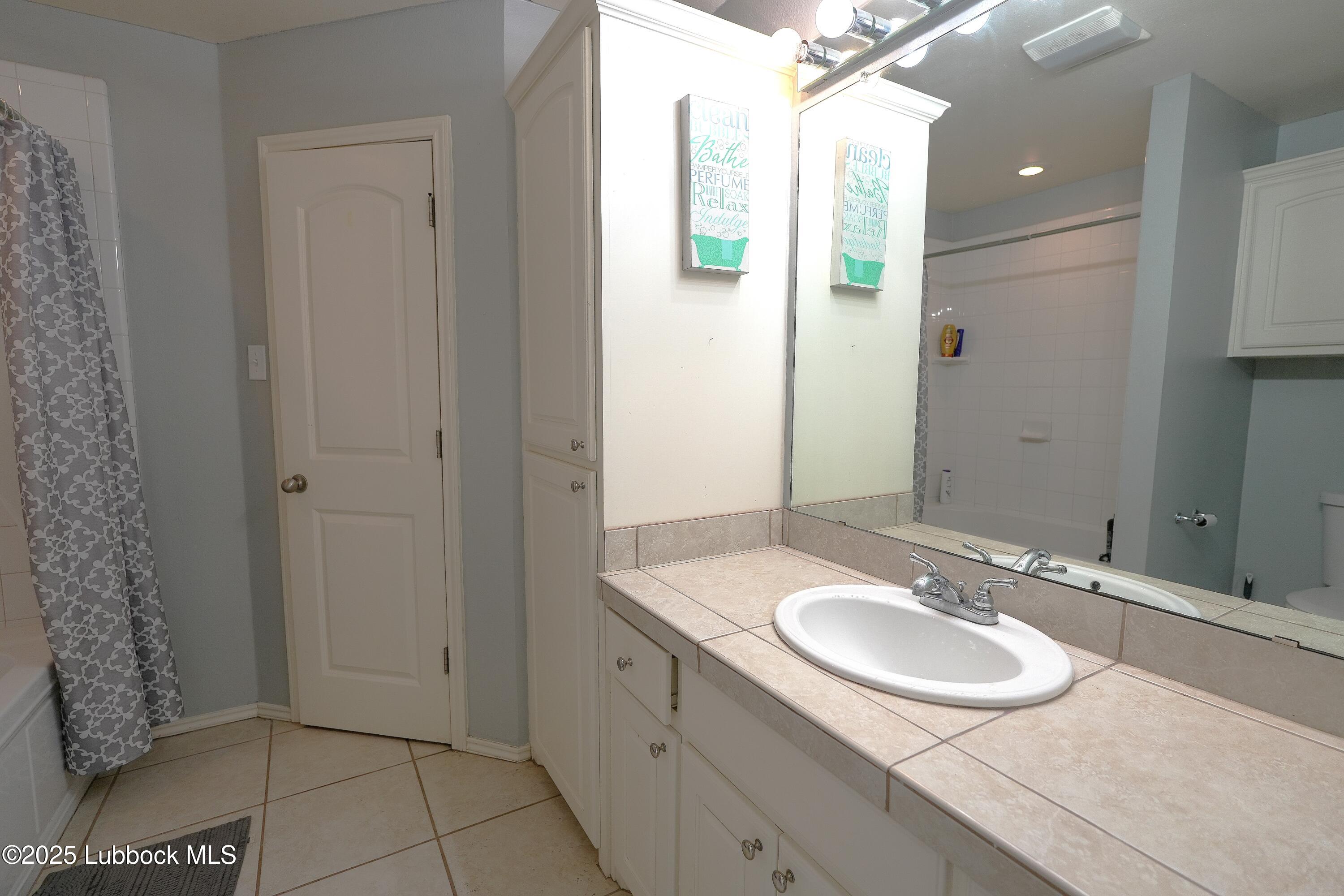 5904 110th Street Lubbock, TX 79424 - Photo 26 of 32 a bathroom with a sink and a mirror