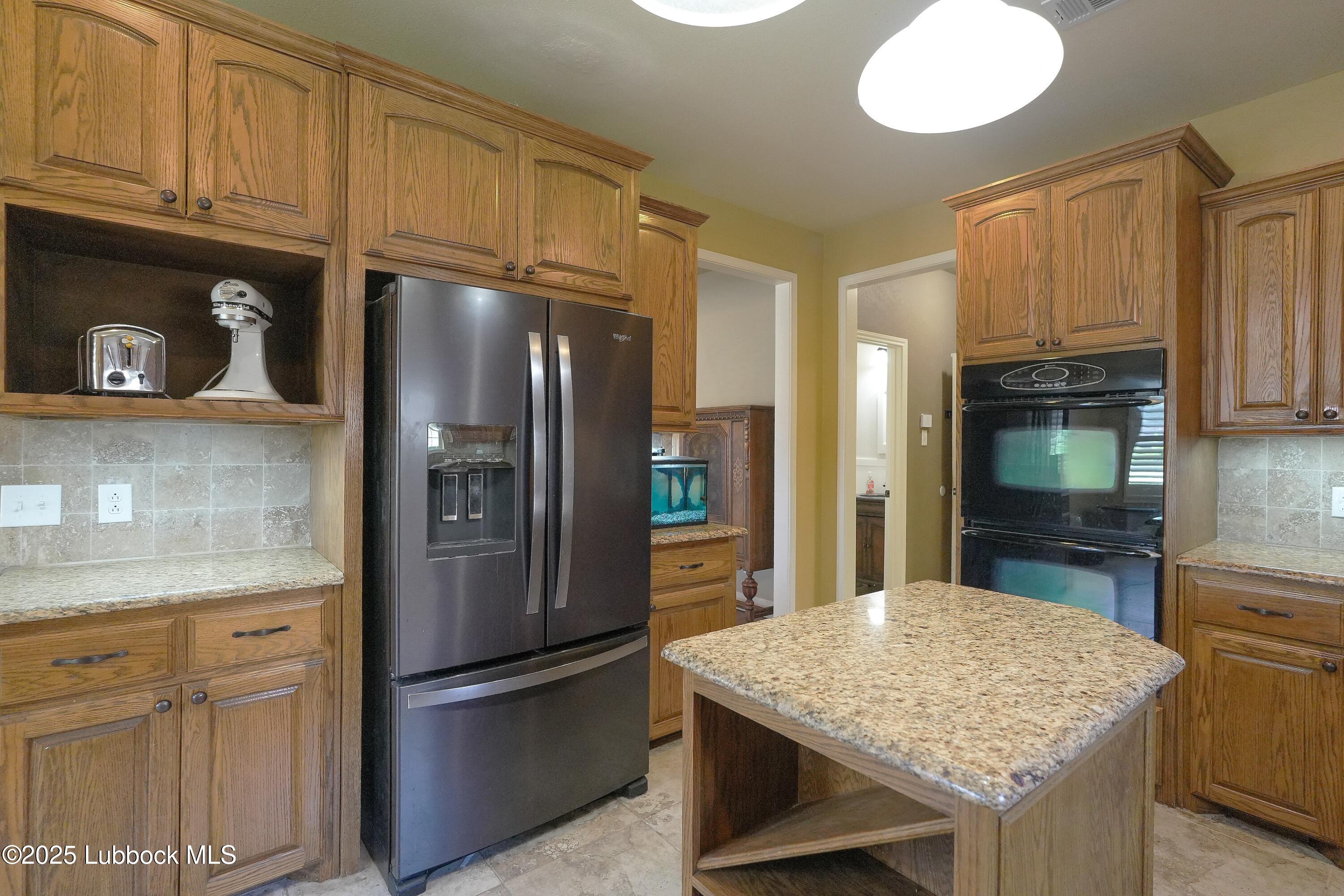 5904 110th Street Lubbock, TX 79424 - Photo 7 of 32 a kitchen with stainless steel appliances granite countertop a refrigerator a stove and a sink