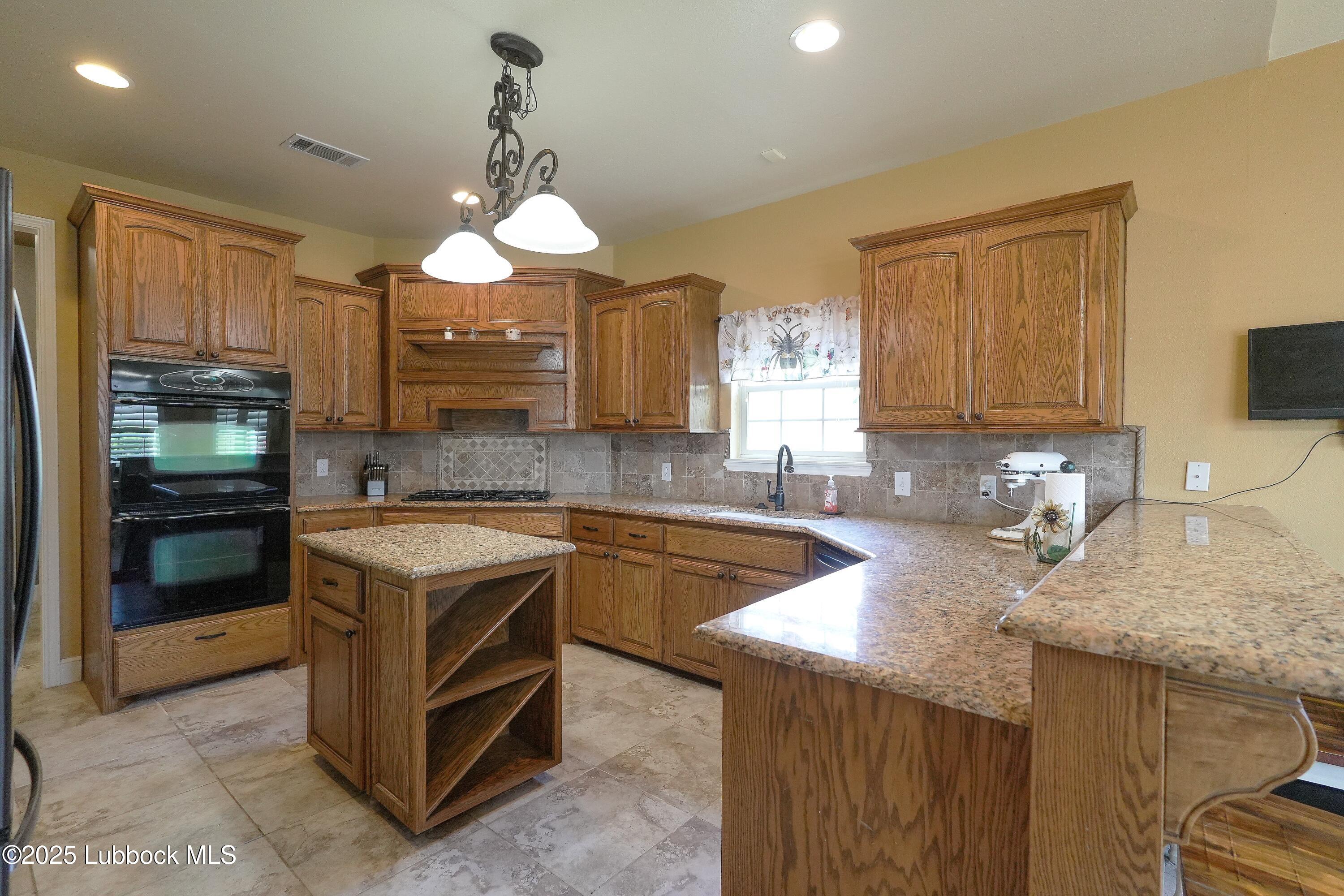 5904 110th Street Lubbock, TX 79424 - Photo 9 of 32 a kitchen with a stove a sink and a microwave