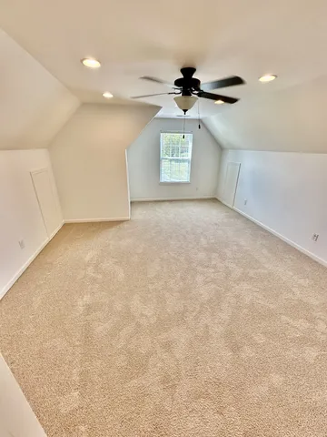 an empty room with windows and ceiling fan