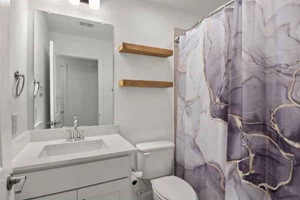 a bathroom with a sink a toilet and a mirror