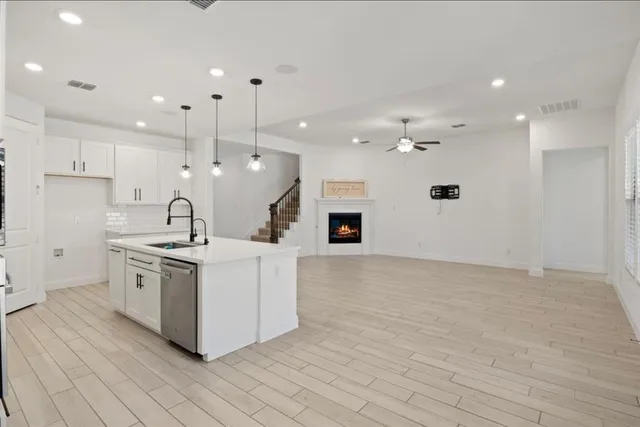 a large kitchen with stainless steel appliances a large counter top a stove a sink and a refrigerator