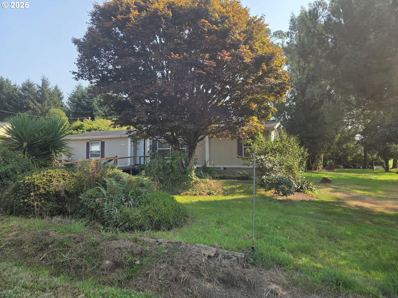 9225 Millcreek Road Tillamook, OR 97141 - Photo 2 of 19 a backyard of a house with a garden and outdoor seating